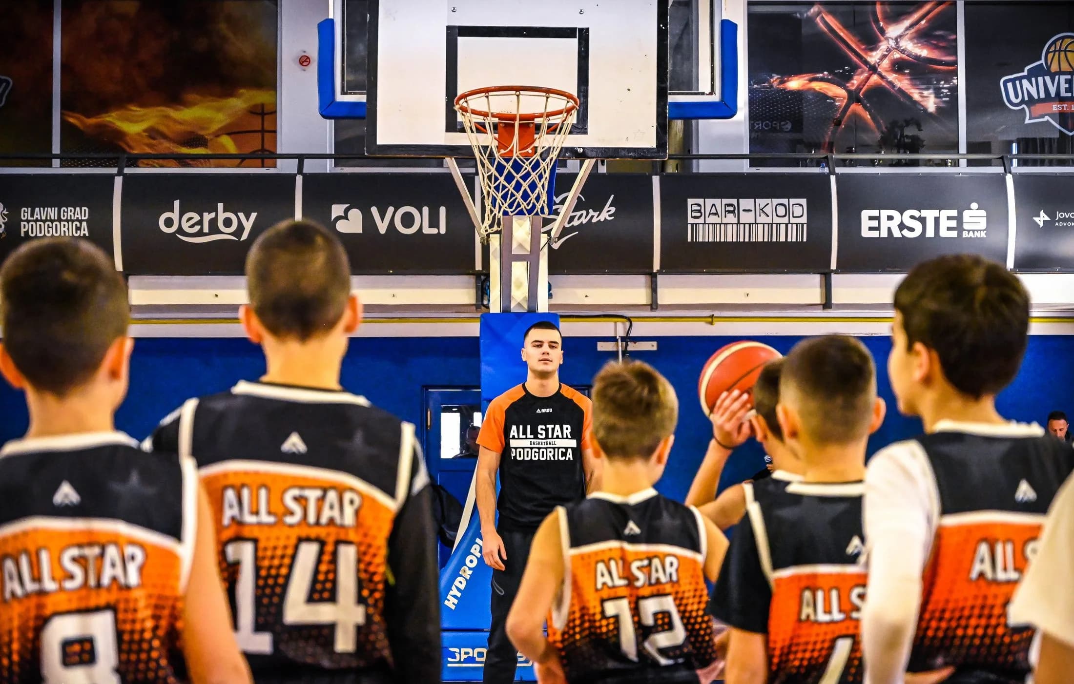 A coach talking to young KK All Star players during practice